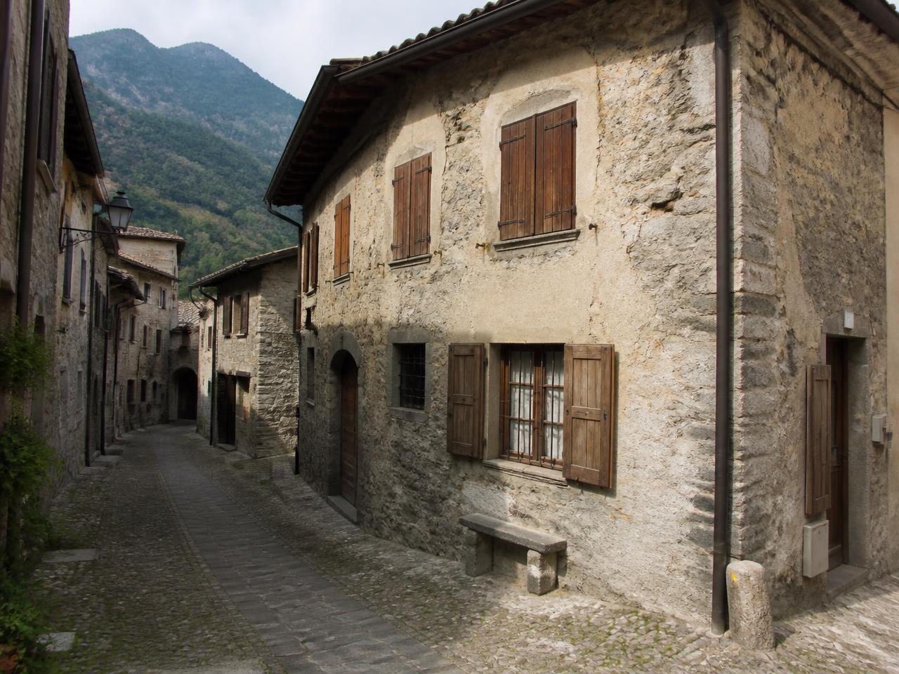 Casa in pietra con persiane in legno in un borgo dei Monti Sibillini